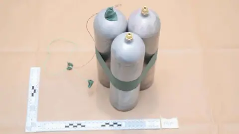 METROPOLITAN POLICE Three large silver canisters taped together with green tape are pictured in a police photo