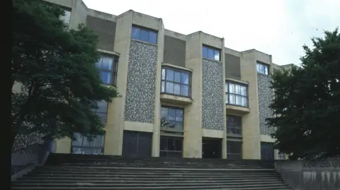 Winchester Crown Court building from the outside. It is a brown building with wide steps leading up to the entrance.
