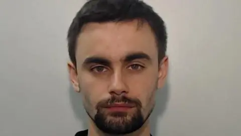 Greater Manchester Police Hugh Nelson who has dark brown hair and beard with hazel eyes