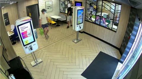 Metropolitan Police CCTV showing Daniel Khalife with a face mask and hat in McDonald's