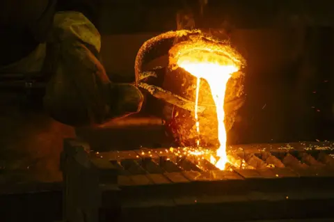 Getty Images A worker pours molten gold into a mould during the refining of bullion at a plant in South Africa, on 16 August 2017