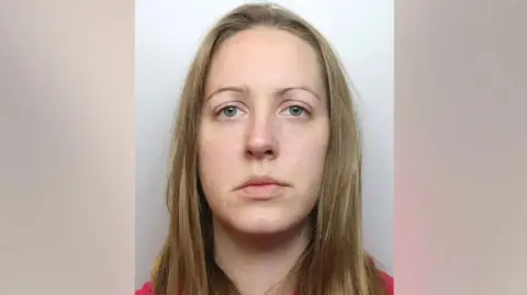 Cheshire Constabulary A police mugshot of Lucy Letby, who has straight blonde hair and stares at the camera with a blank expression.