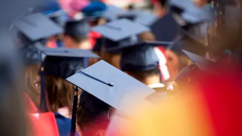 Getty Images Students wearing mortarboards are gathered together at a graduation.