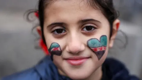 Lareen, 8, looks on as people gather in Trafalgar Square, London, on December 8, 2024