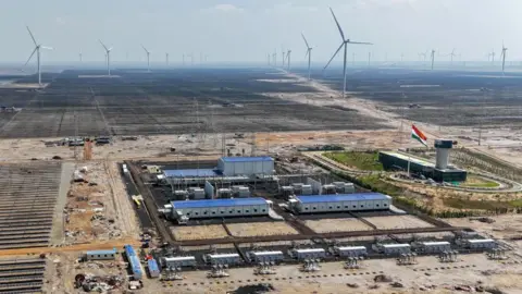 Getty Images This aerial photograph taken on October 15, 2024 shows solar panels installed at the Adani Green Renewable Energy Plant in Khavda, in India's Gujarat state.