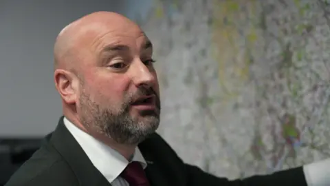 Police and Crime Commissioner (PCC) for Lincolnshire Marc Jones points at a map of the policing areas he is responsible for