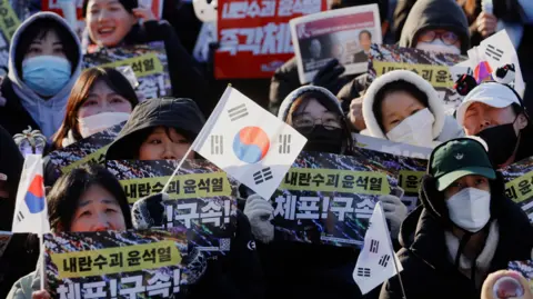 EPA Protesters hold the South Korean flag and placards at a rally against South Korea's impeached President Yoon Suk Yeol, in the capital of Seoul.