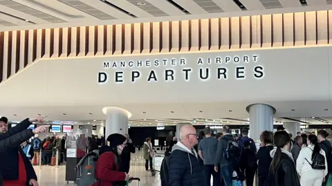 Reuters Passengers queue for security screening in the departures area of Terminal 2 at Manchester Airport.