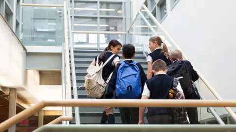 Getty Images Stock image of five school pupils walking up some stairs