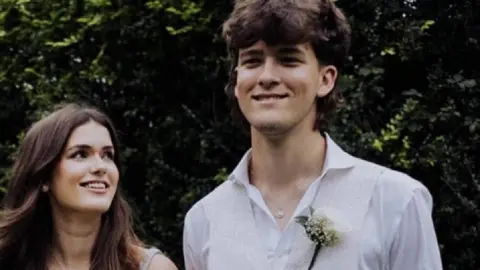 FAMILY HANDOUT Hamish Wilson is standing smiling next to his sister Izzie