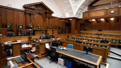 PA Media Court No 1 of the Old Bailey, showing the wood panelled benches for the judge, barristers and jury.