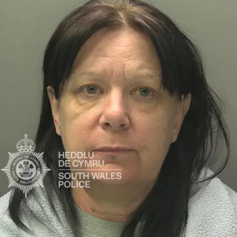 South Wales Police Mugshot of Catherine Francis, who has long dark hair and is wearing a grey top