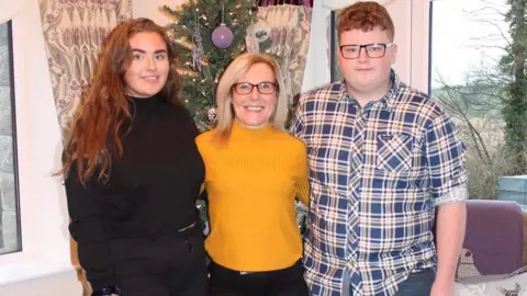 FAMILY HANDOUT Jeni Larmour standing alongside her mother Sandra and brother Daniel at their home in County Armagh.