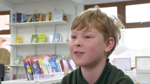 Ten-year-old Jacob, a pupil at St Peter's Primary School, sitting in the school library.
