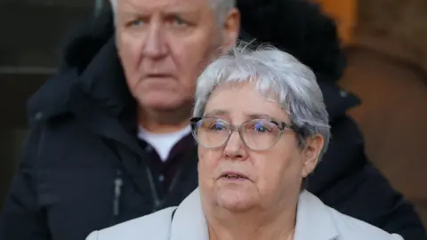 PA Media Margaret McKeich outisde court with her husband Allan