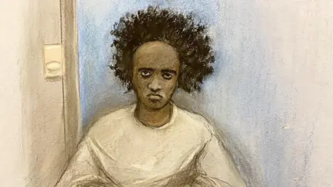 Elizabeth Cook/PA A court sketch of Axel Rudakubana, who has bushy black hair and sits in a room with a blank expression.