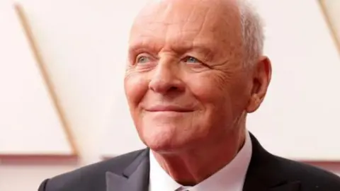 Getty Images Anthony Hopkins wearing a dark suit and white collared shirt at the Oscars