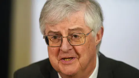 PA Media A head and shoulders picture of Mark Drakeford, wearing a black suit and glasses.