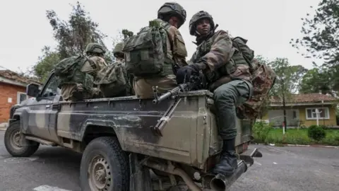 EPA-EFE/REX/Shutterstock M23 rebels in Goma (file photo); soldiers sit on the back of a truck.