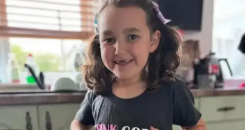 Family handout A smiling Bebe King shows off her t-shirt, which has a logo from the Wicked musical, and the caption "pink goes with green".
