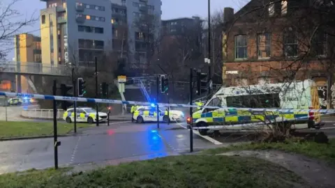 BBC/Xanthe Palmer Three police vans parked across a taped-off road.
