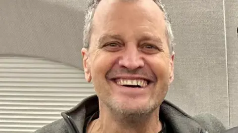 Courtesy Anne Fogel Marc Fogel has a wide smile on his face and is wearing a grey fleece sweater.