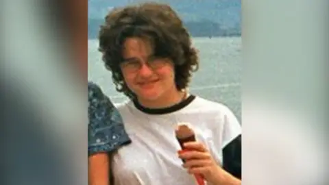 Family Handout Young woman wearing a wearing a white t-shirt and glasses holding an ice cream.