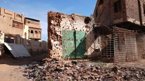 Getty Images A pockmarked and destroyed building in Khartoum, with rubble in the foreground.