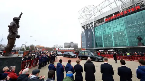 Reuters Thousands of fans clapping at Manchester United's Old Trafford as Denis Law's funeral cortege arrives