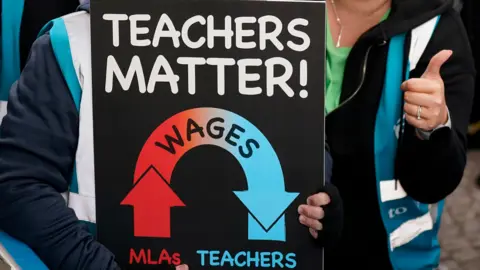 PA Media A placard that says 'teachers matter'