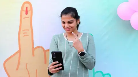 EPA A woman takes a selfie after voting in Delhi election