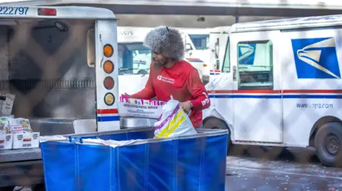 EPA A United States Postal Service (USPS) worker in a red shirt loads a mail car in Miami, Florida, USA, 05 February 2025.