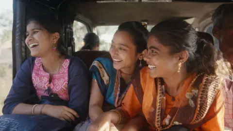 Courtesy: Sthal A still from the Marathi film Sthal: A Match shows three laughing young women. The lead character played by Nandini Chikte is on the right