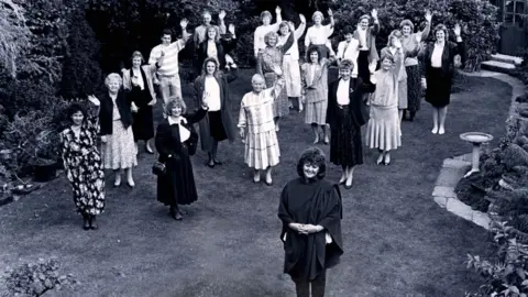 Slimming World A black and white photo of Margaret Miles-Bramwell with Slimming World head office staff stood behind her in 1989