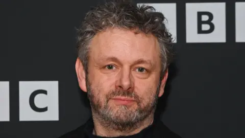 Getty Images A picture of Michael Sheen at a photo call for BBC drama "The Way" at the BFI Southbank on February 5, 2024 in London, England. It is a close up image of Sheen's face. He is standing in front of the BBC background.