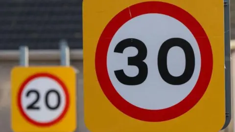 Getty Images A 30mph speed limit sign in front of a 20mph speed limit sign