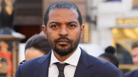 PA Media Noel Clarke in a dark suit outside court, looking serious