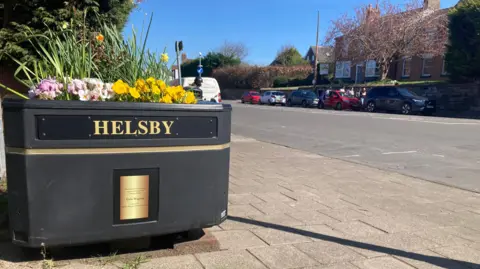A planter with a sign saying Helsby on in Helsby, Cheshire