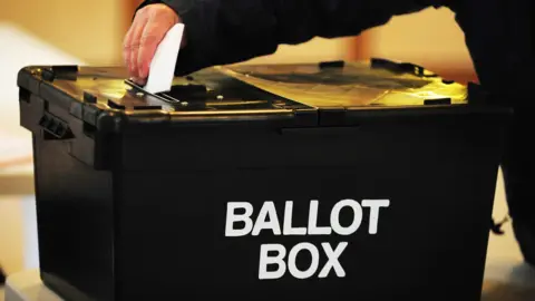 PA Media A generic image of a black ballot box with someone depositing a voting slip