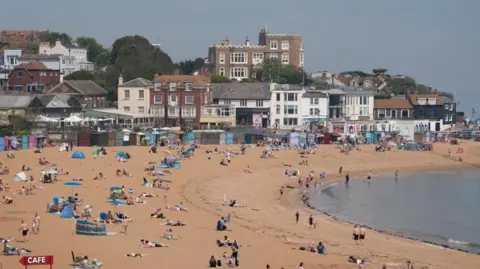 PA Media People relaxing on the beach in Kent