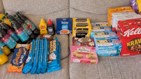 Robert A sofa with lots of products on it, ranging from pastries and biscuits to cereal and teabags