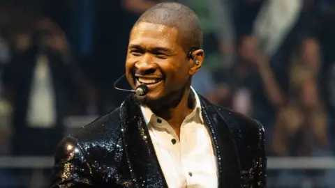 Getty Images Usher performs in a black, sequinned jacket and white shirt on stage on night 8 of his Past Present Future tour at The O2 Arena on April 11, 2025 in London, England