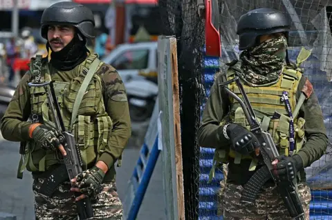 AFP via Getty Images Indian paramilitary personnel stand guard along a road in Srinagar on May 7, 2025, following border tensions. India and Pakistan exchanged heavy artillery along their contested frontier on May 7, after New Delhi launched missile strikes on its arch-rival in a major escalation between the nuclear-armed neighbours. New Delhi announced it had carried out "precision strikes at terrorist camps" at nine sites in Pakistan-administered Kashmir, days after it blamed Islamabad for a deadly attack on the Indian-run side of the disputed region. (Photo by Sajjad HUSSAIN / AFP) (Photo by SAJJAD HUSSAIN/AFP via Getty Images)