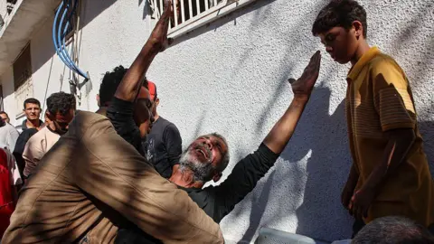 AFP A Palestinian man reacts following an Israeli strike on Gaza City's Thailandy restaurant and its vicinity on 7 May 2025