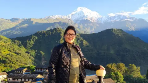 Lucky Chhetri Lucky Chhetri, one of the pioneering women trekking guides in Nepal, poses in front of the Himalayas which can be clearly seen
