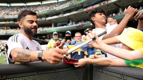 Getty Images Virat Kohli of India signs autographs for fans prior to the start of day one of the Men's Fourth Test Match in the series between Australia and India at Melbourne Cricket Ground on December 26, 2024 in Melbourne, Australia.