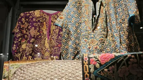 An exhibit showcasing Parsi garments with embroidery inspired by Chinese and European prints at a newly renovated Parsi museum in Mumbai. 