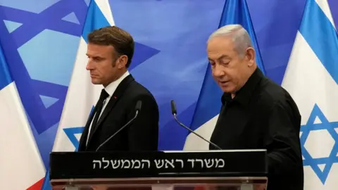 Reuters President Emmanuel Macron of France enters a press conference next to Israeli Prime Minister Benjamin Netanyahu.