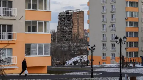 EPA-EFE/REX/Shutterstock A damaged block of flats behind two new blocks built by Russia's occupying forces in February 2025