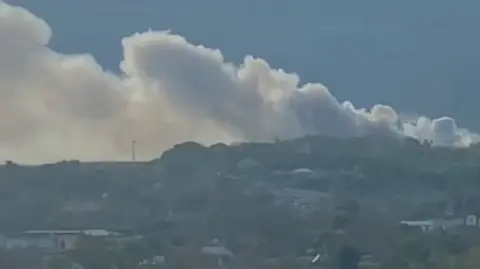 Smoke billows from a rural landscape in Crimea